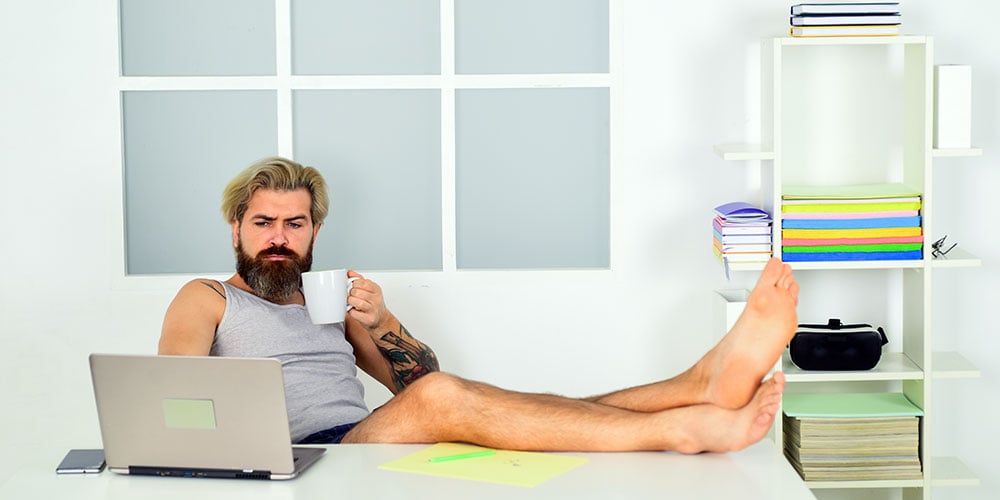 Barefoot man working at a desk