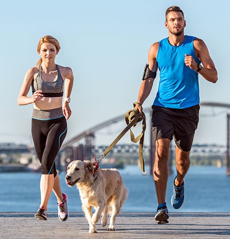 Couple running with a dog