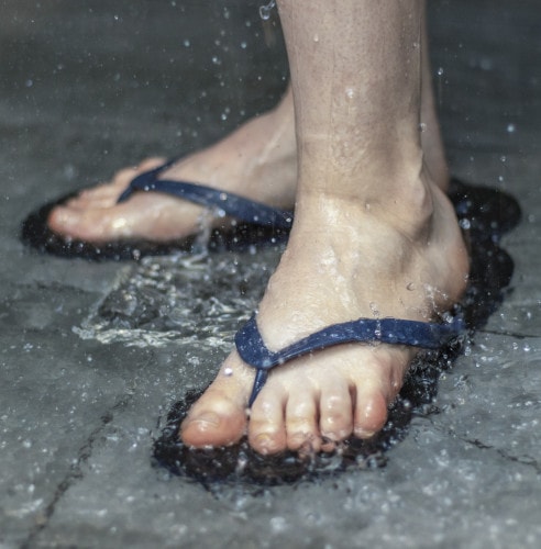 Close up of feet in flip flops in the shower