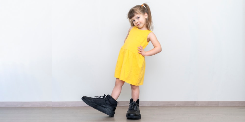 Little girl wearing oversized men's shoes